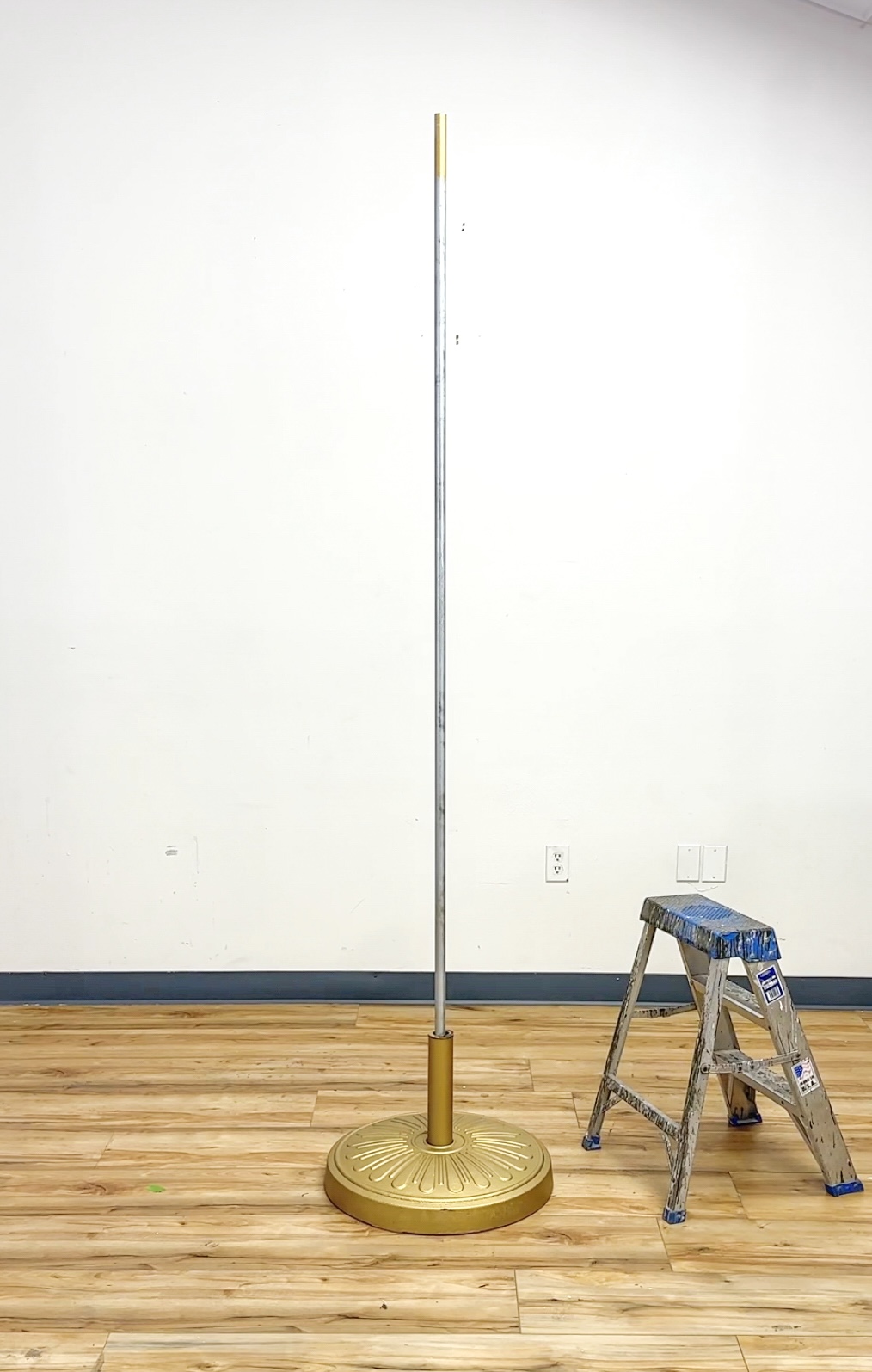 wood christmas tree gold base holding empty metal conduit